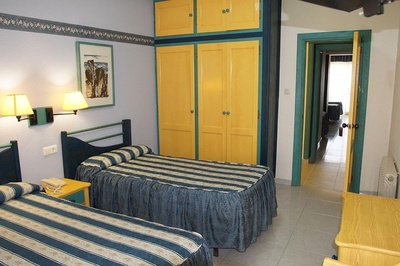 una habitación con dos camas y un armario amarillo