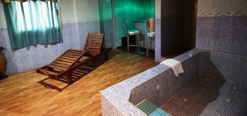 una habitación con una bañera y dos sillas de madera