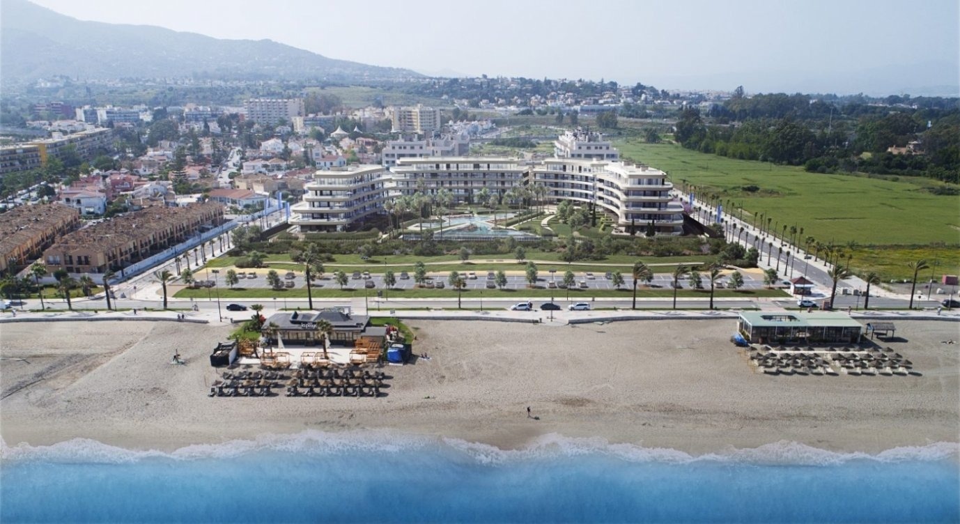 una vista aérea de una playa con un gran edificio en el fondo