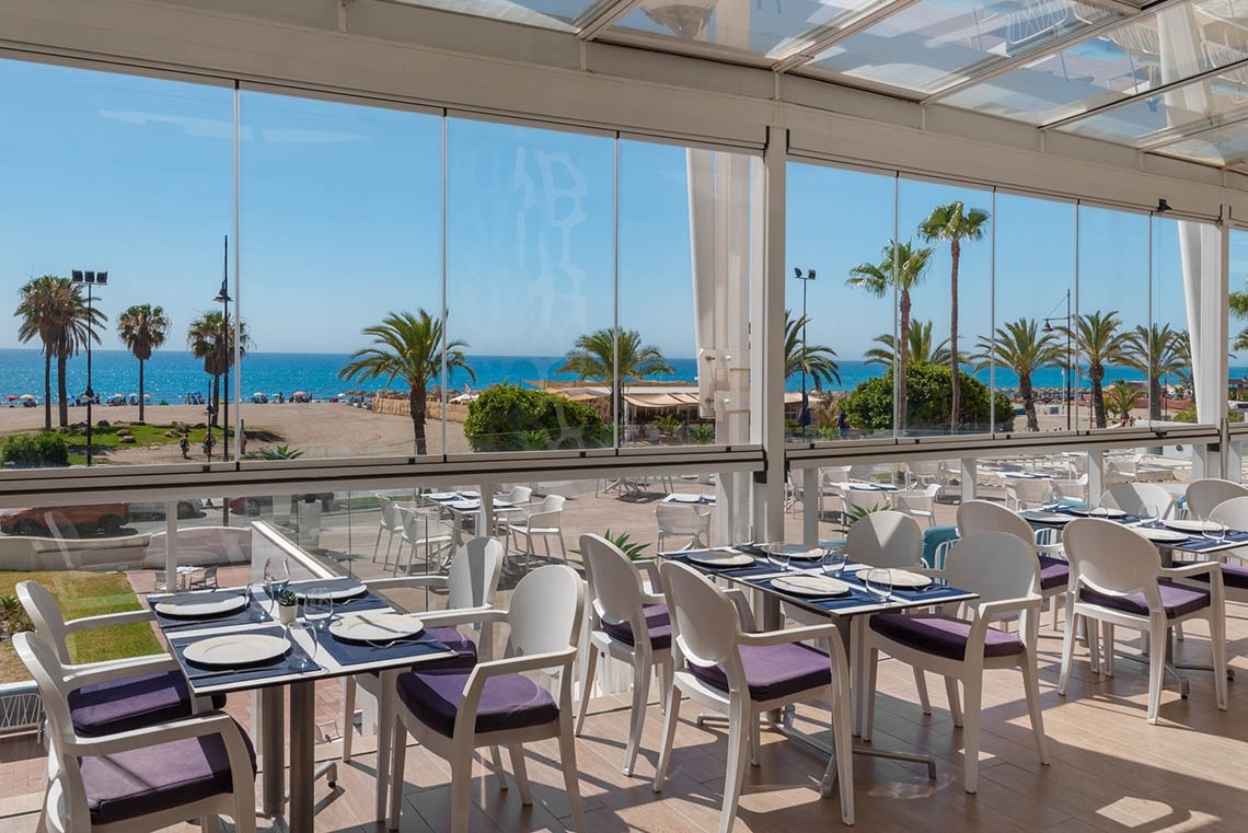 un restaurante con mesas y sillas y una vista al océano