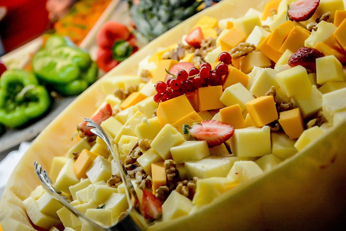 un plato lleno de queso y frutas con un tenedor