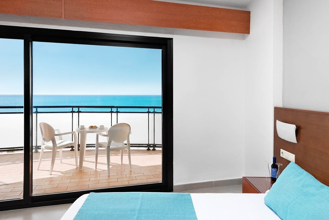 a hotel room with a balcony overlooking the ocean