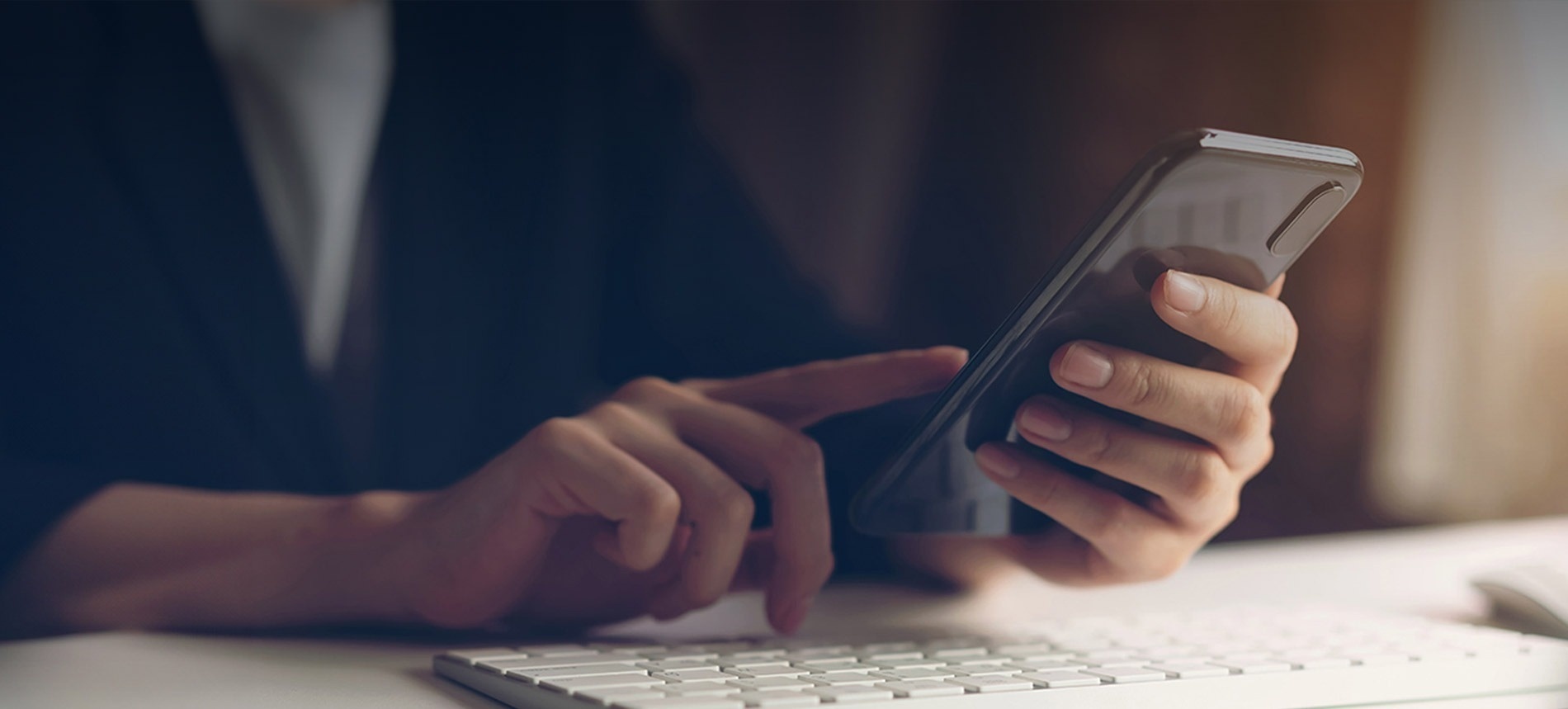 una persona está usando un teléfono inteligente junto a un teclado