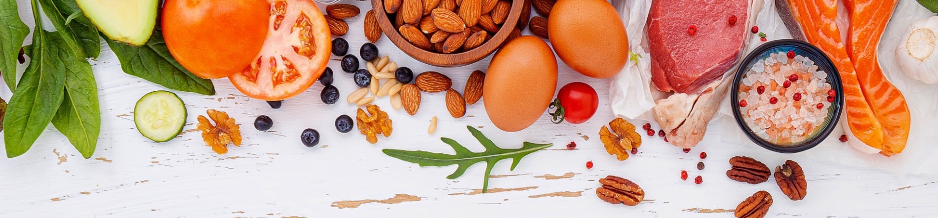 una variedad de alimentos saludables están dispuestos en una mesa blanca .