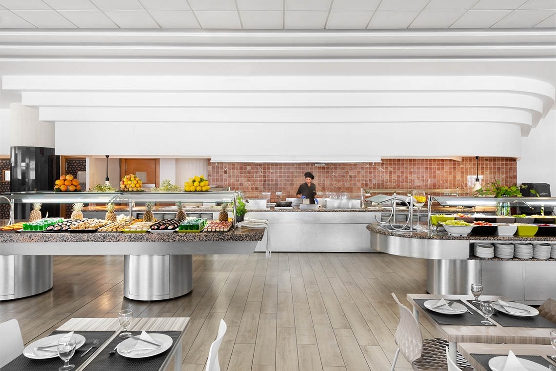 un buffet en un restaurante con un chef en el fondo