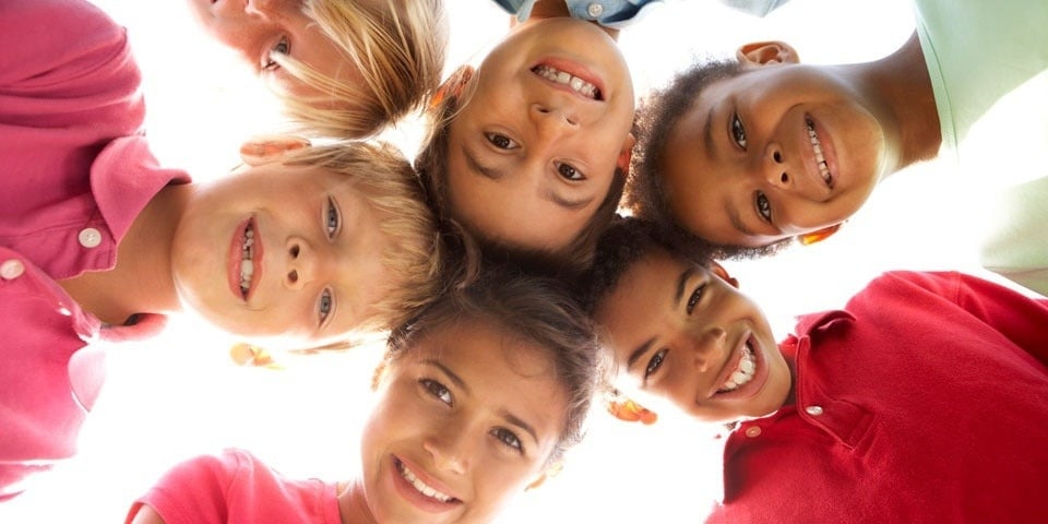 a group of children are standing in a circle and smiling