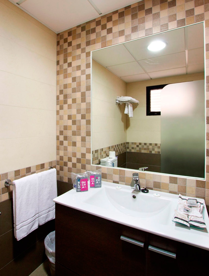 ein Badezimmer mit einem Waschbecken und einem großen Spiegel