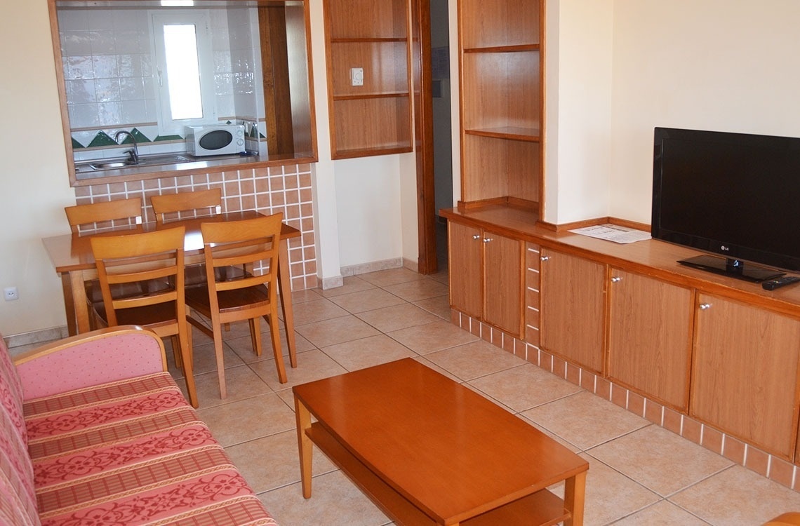 una sala de estar con una mesa y sillas y una televisión lg