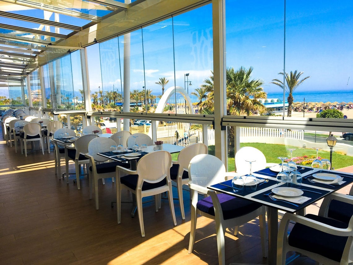 un restaurante con mesas y sillas y una vista al océano