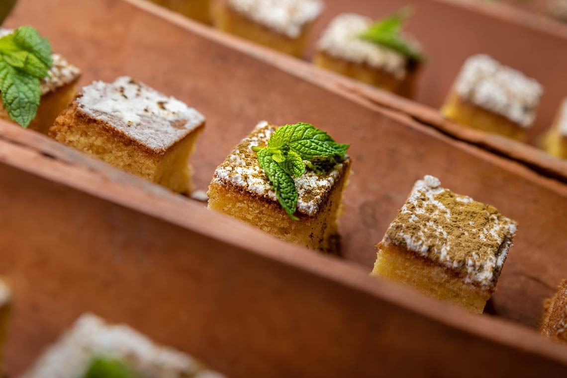 a piece of cake with powdered sugar and mint leaves on top