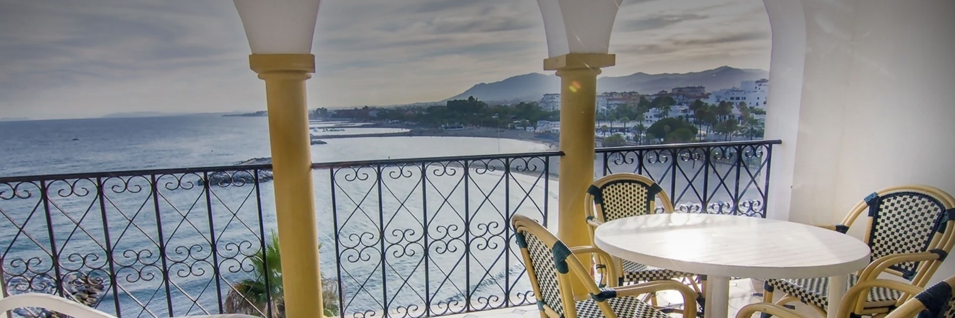 a balcony with a table and chairs overlooking the ocean