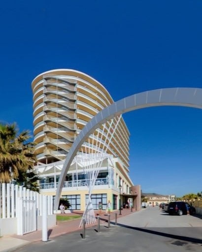 un grand bâtiment avec de nombreux balcons est entouré d' une arche .