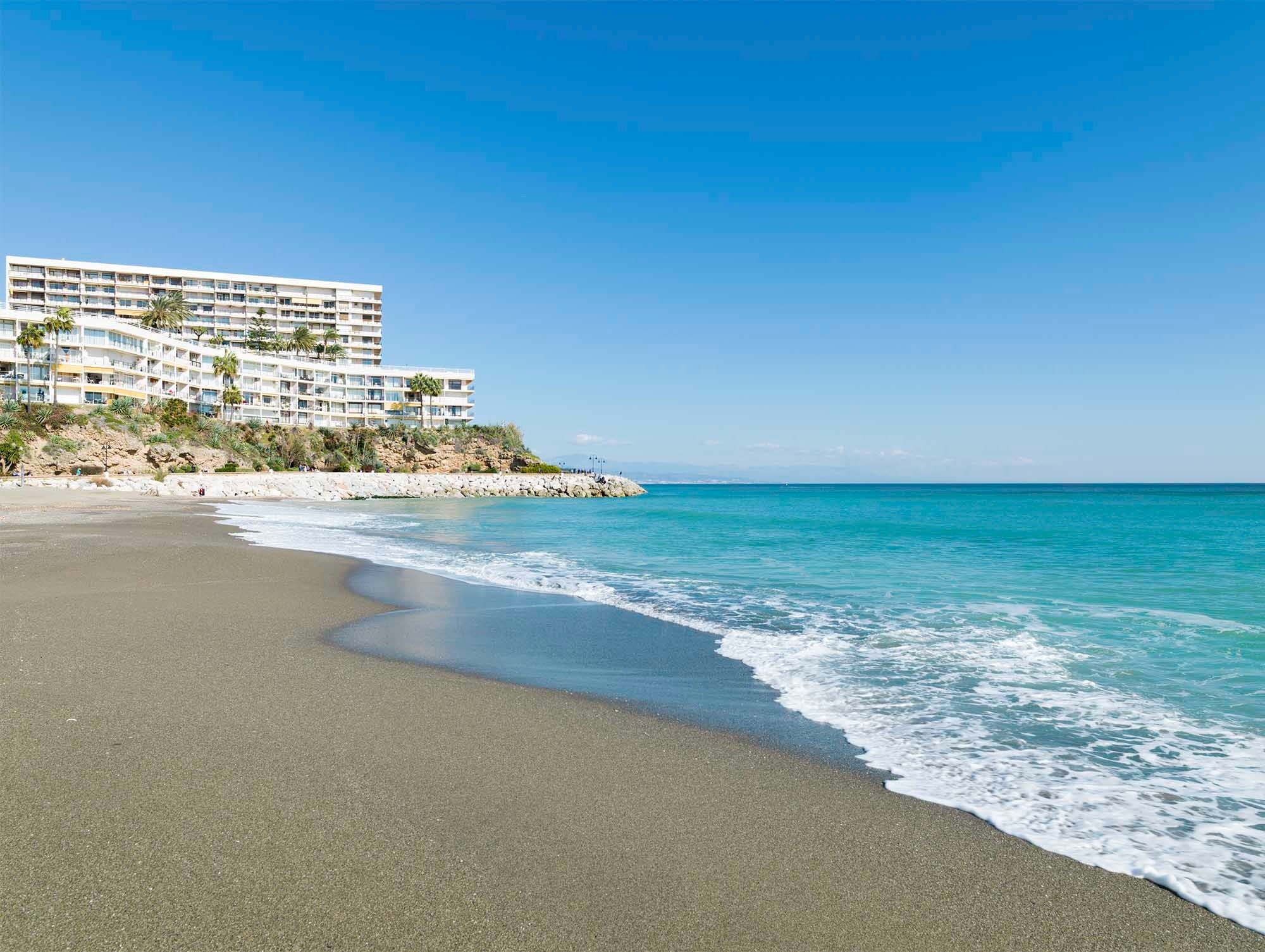 a beach with a large building in the background