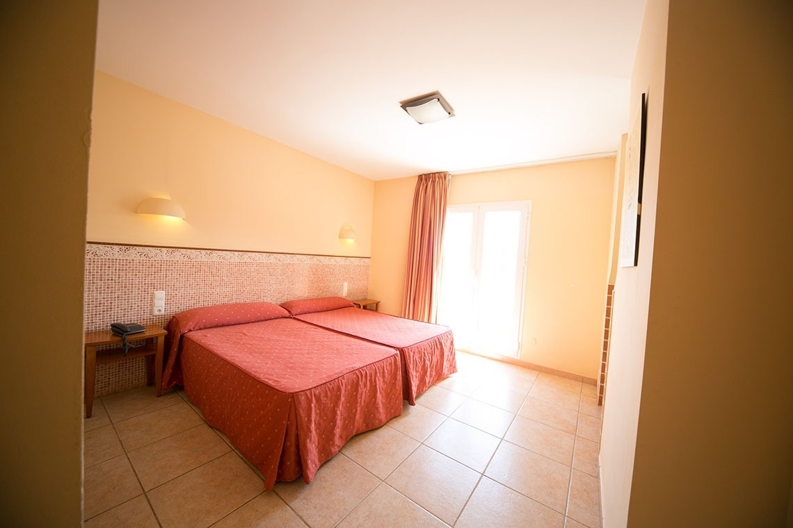 una habitación con dos camas y una ventana