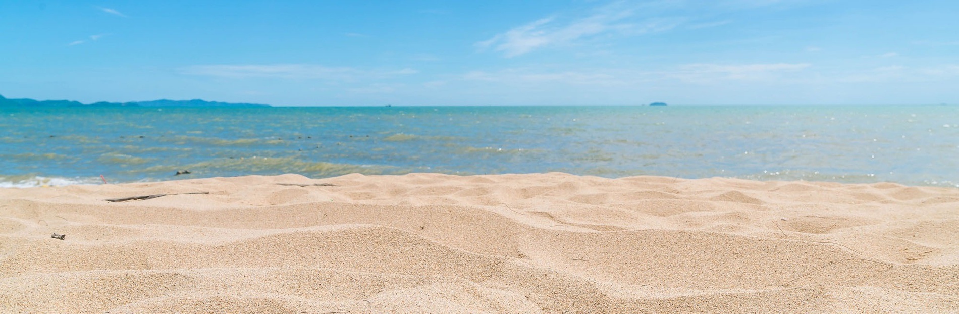 una playa vacía con el océano en el fondo