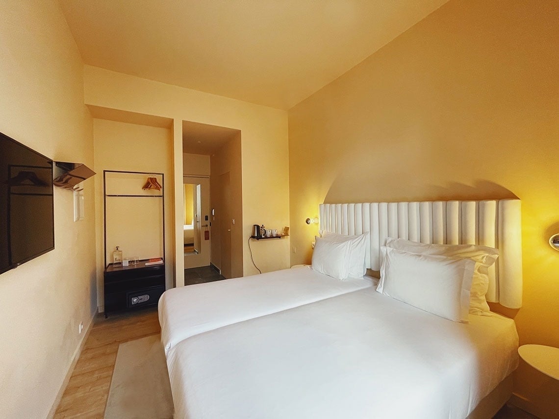 Quarto de hotel com duas camas brancas e paredes amarelas, TEST3: Copia 4.