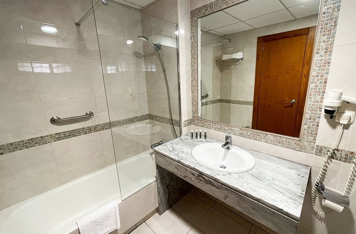 un baño con bañera , lavabo y espejo