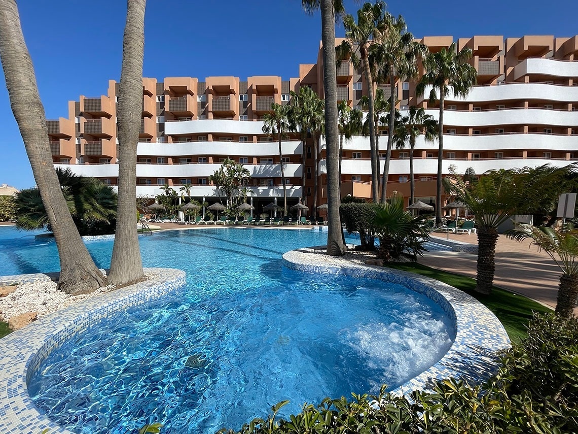 un faro está rodeado de palmeras y bancos