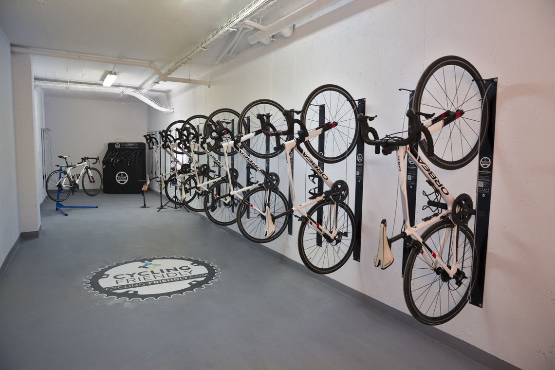 several bikes are hanging on a wall in a room that says cycling friendly
