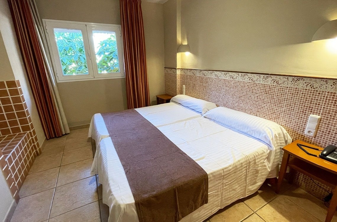 una habitación de hotel con una cama y una ventana