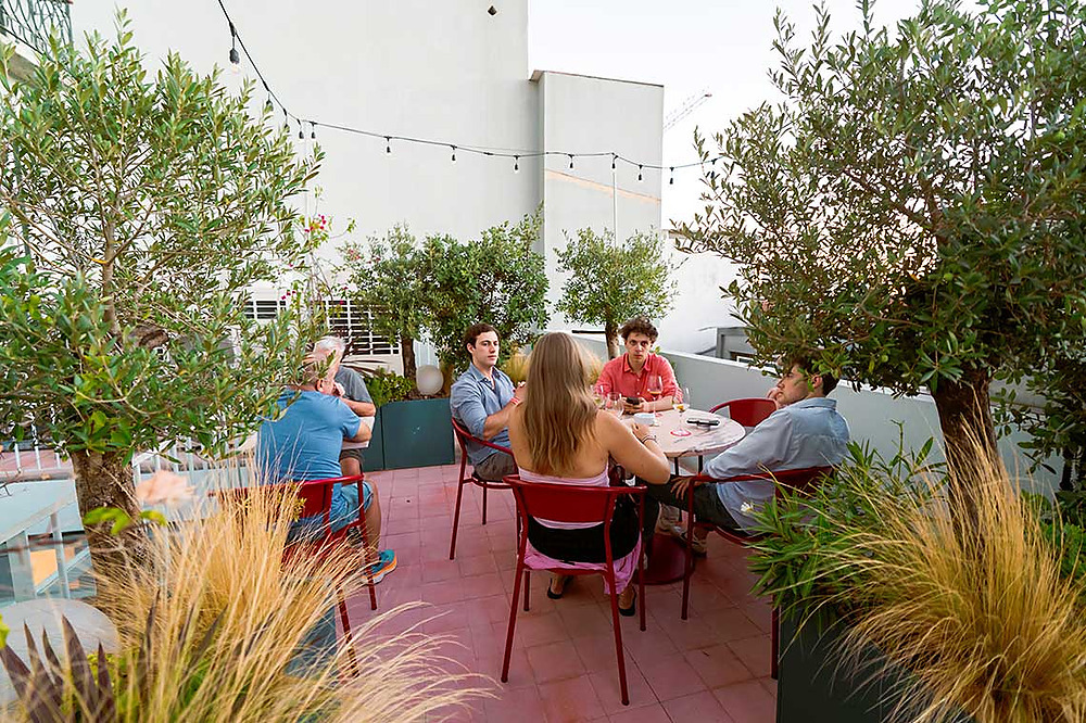 Guests enjoy drinks and conversation at an outdoor rooftop dining area at TEST3: Copia 4.
