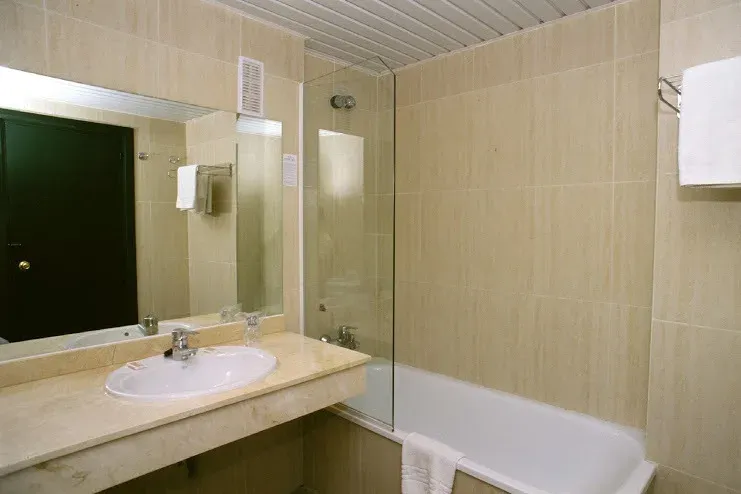 Modern bathroom at Hotel Puente Real, Torremolinos: sink, tub, and shower.