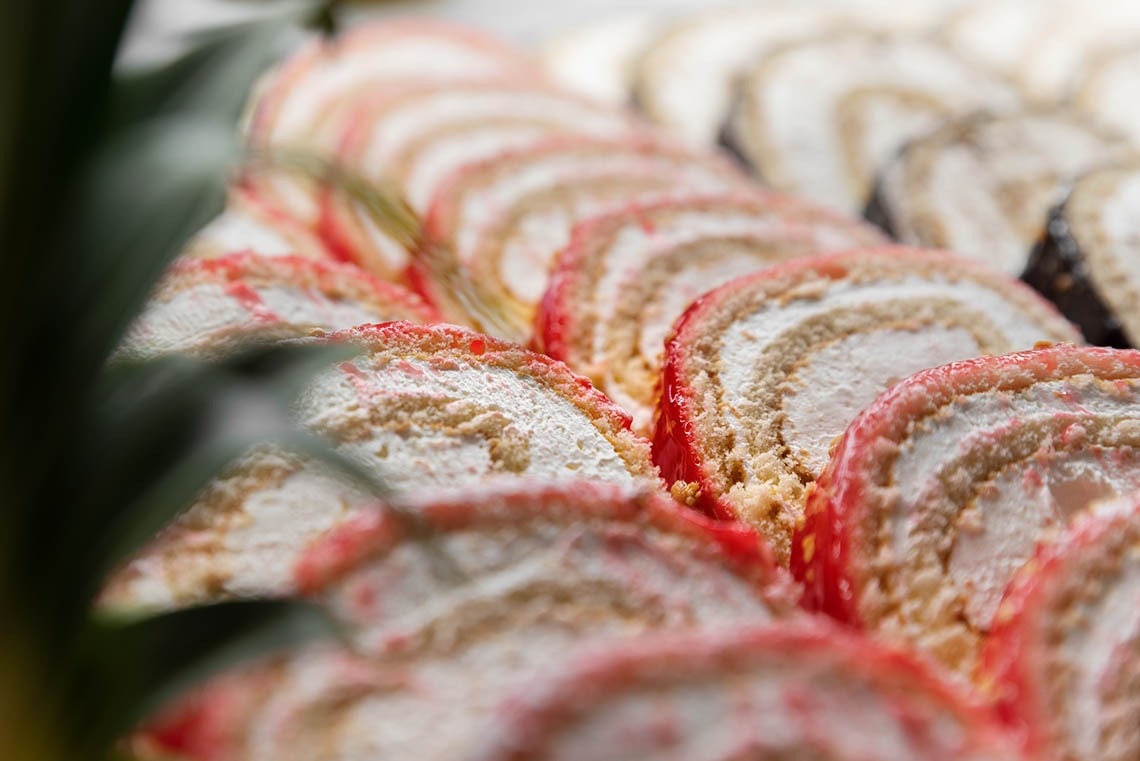 a bunch of rolls of cake with powdered sugar on them