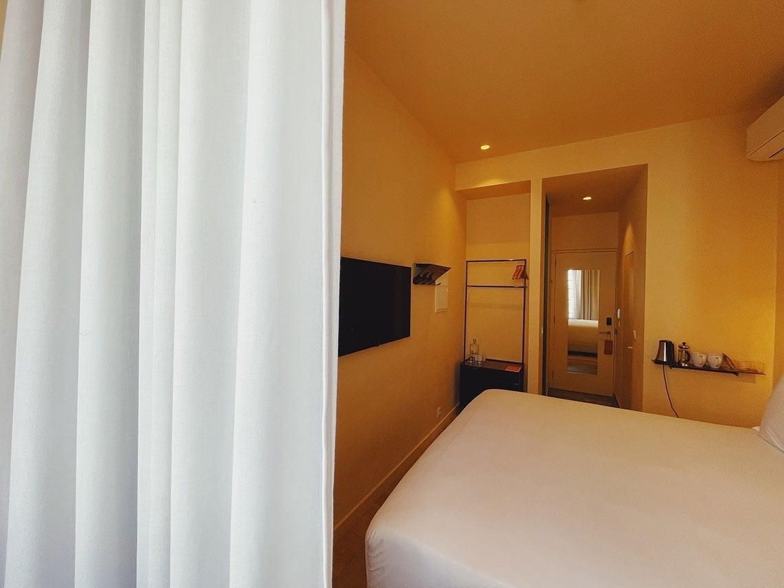 um quarto de hotel com uma cama e uma televisão