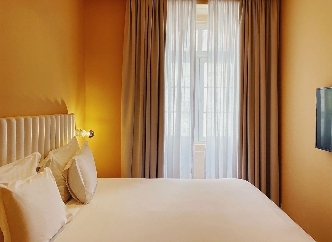 um quarto de hotel com cama , televisão e janela