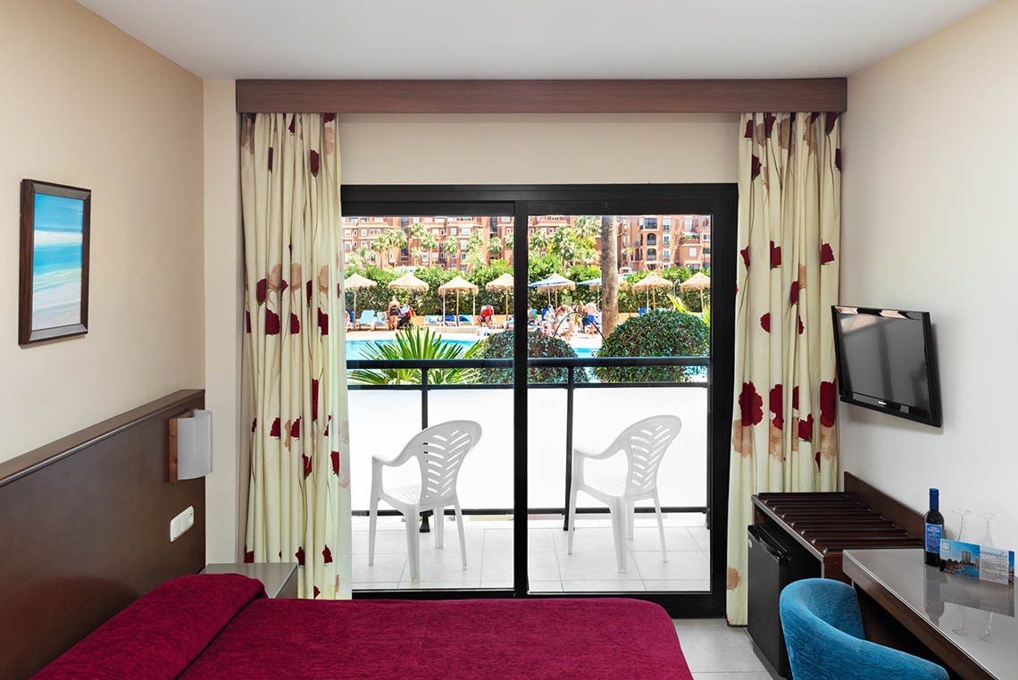 a hotel room with a sliding glass door leading to a balcony