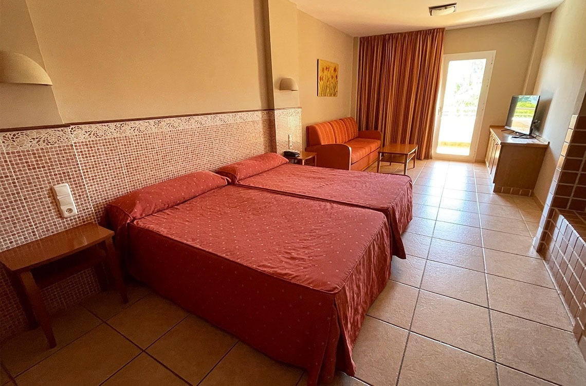 una habitación de hotel con dos camas y una televisión