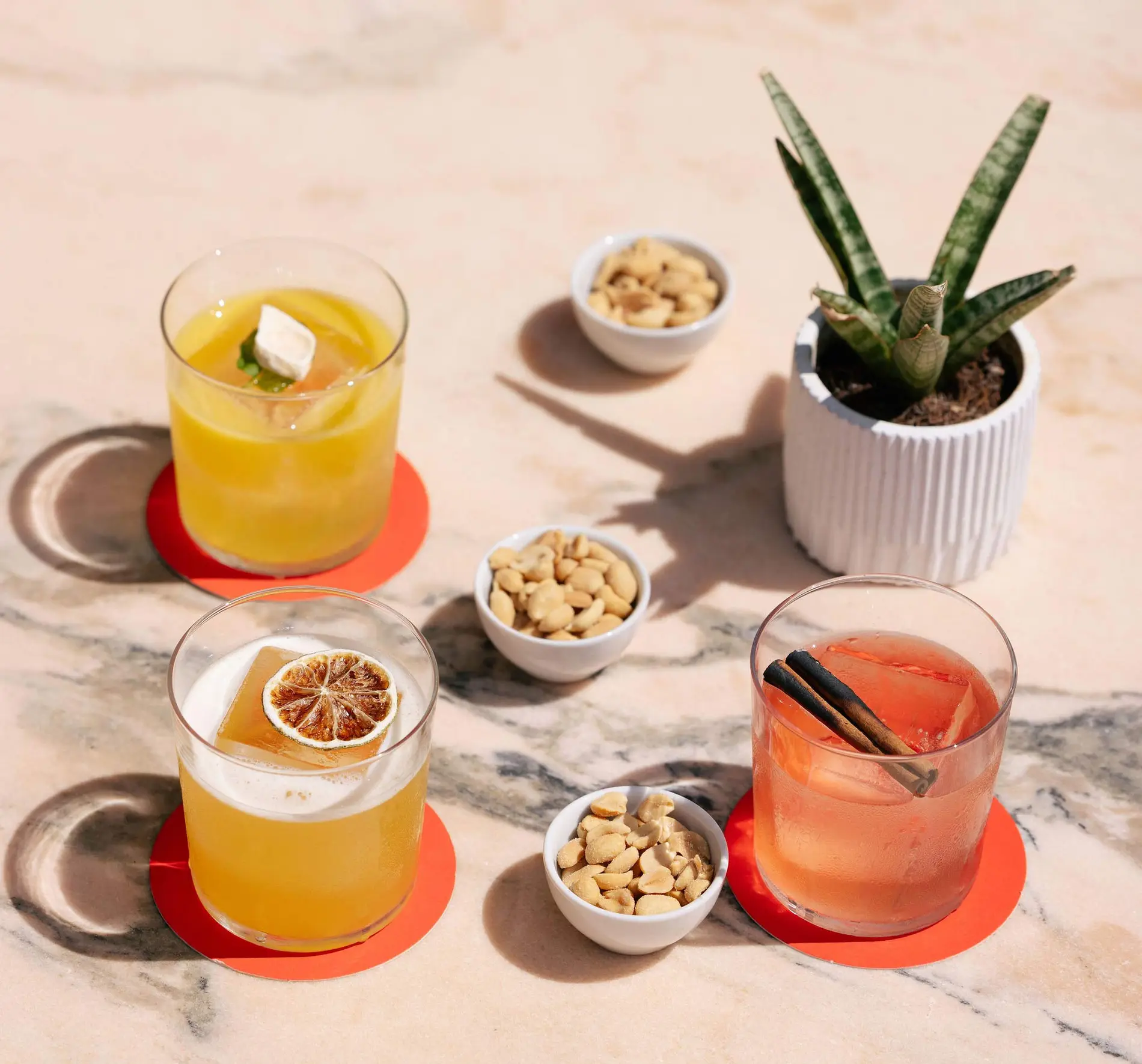 Cócteles y aperitivos en mesa de mármol, perfectos para Esqina Cocktail Bar | Esqina Cosmopolitan Lodge.