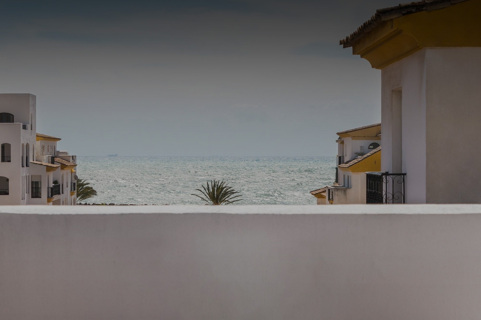 a view of the ocean from the balcony of a building