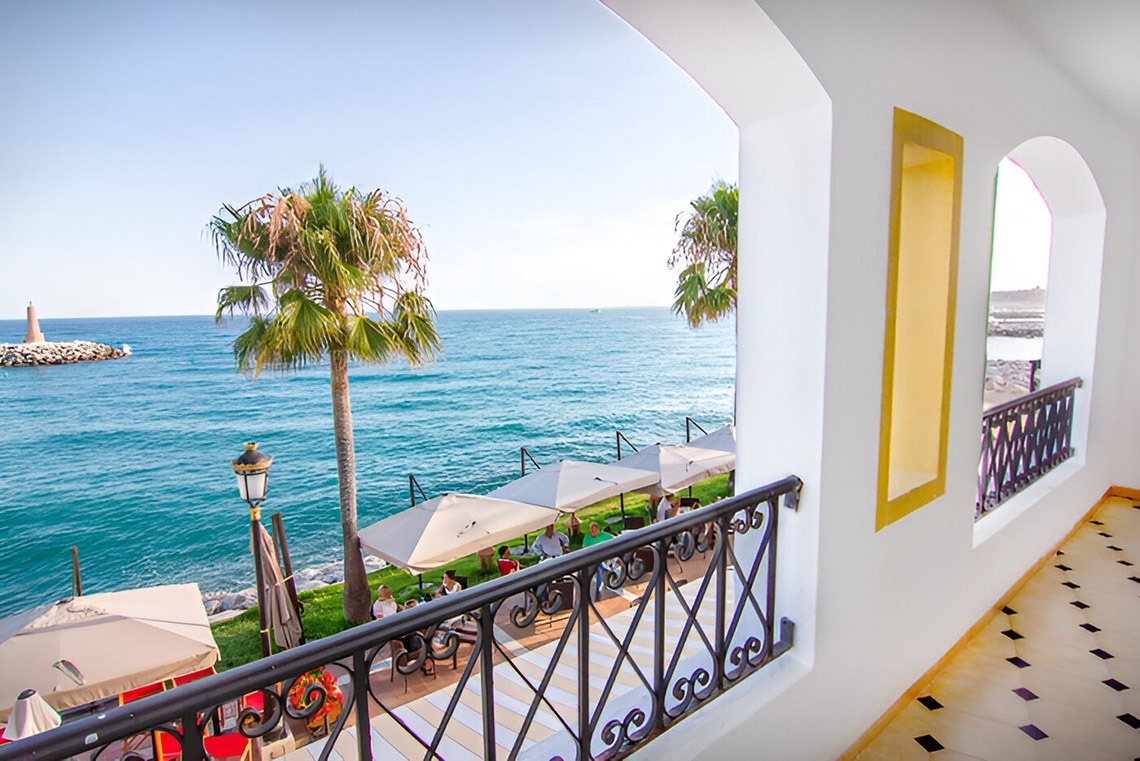 a view of the ocean from a balcony with a wrought iron railing