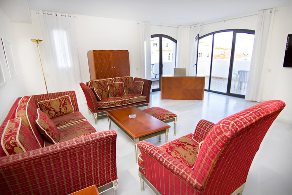 una sala de estar con sofás y sillas rojas