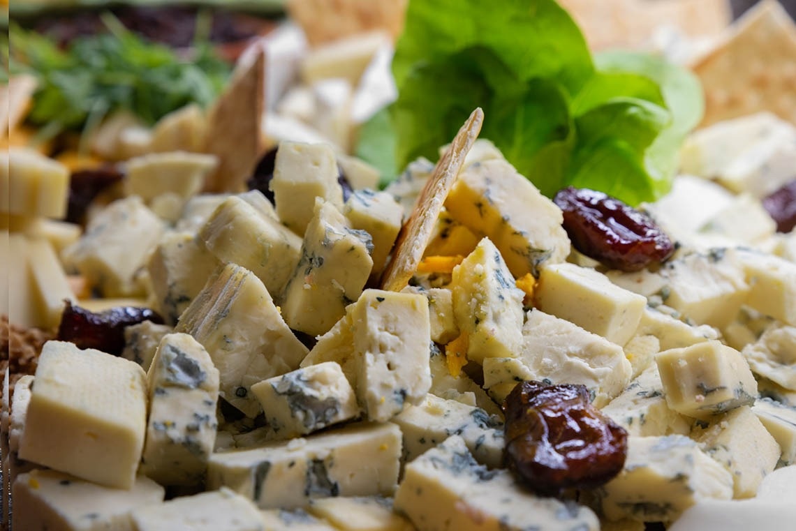 a close up of a salad with cheese and raisins