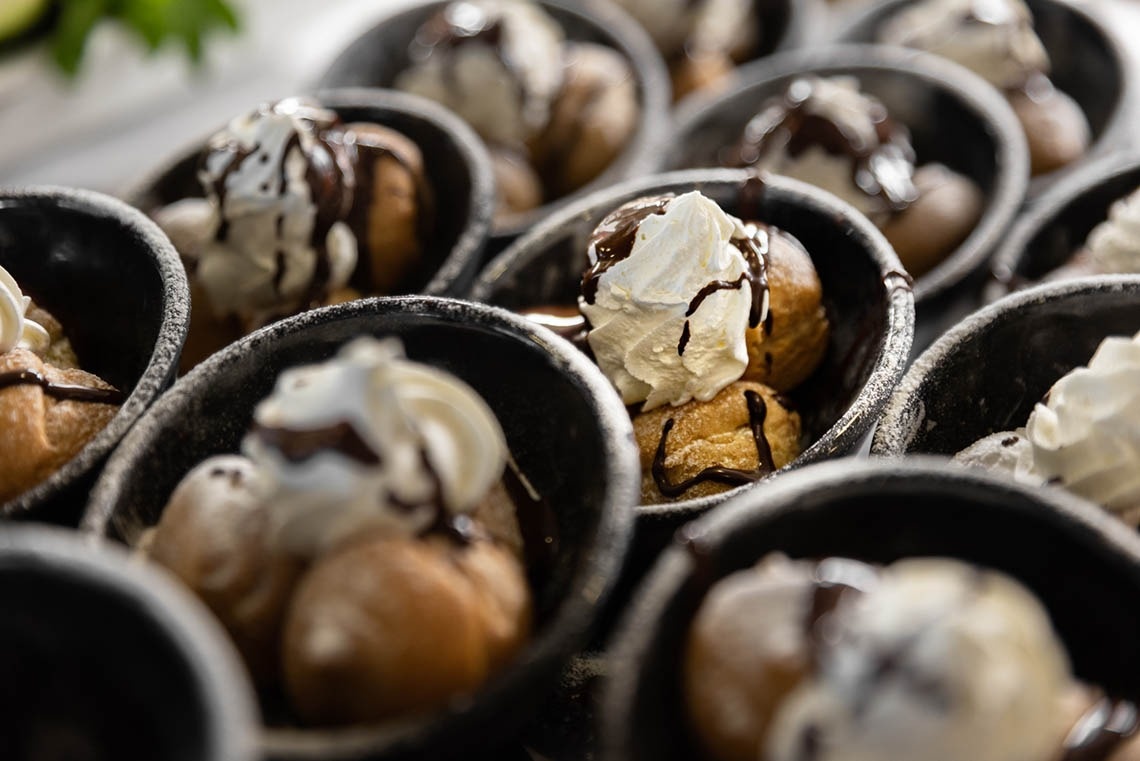 a bunch of desserts with whipped cream and chocolate sauce