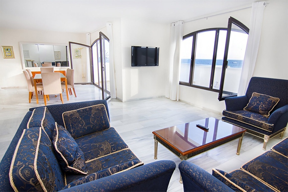 a living room with blue furniture and a flat screen tv