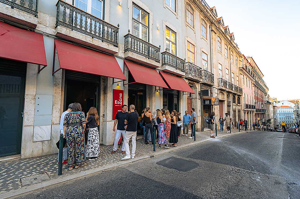 Hotel with red awnings and people outside, ideal for TEST3: Copia 4.