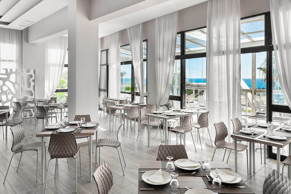 ein Restaurant mit vielen Tischen und Stühlen und vielen Fenstern