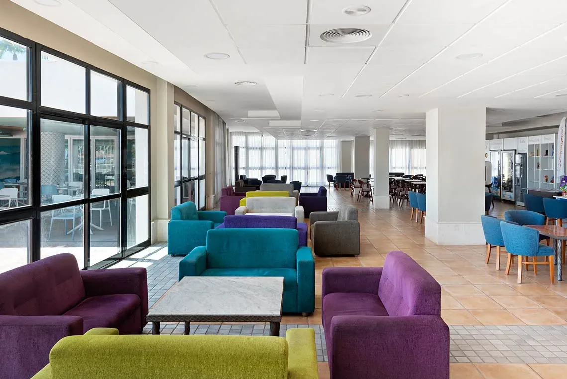 Moderner Salon im Hotel Puente Real Torremolinos mit bunten Sofas.
