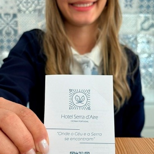 uma mulher está segurando um cartão do hotel serra d' aire