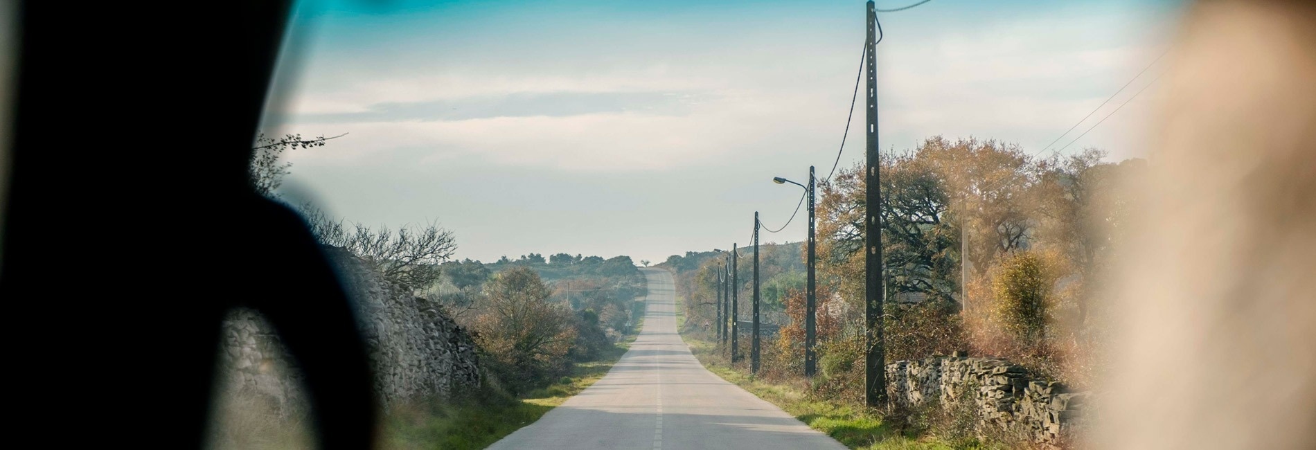 a view of a road through the windshield of a car