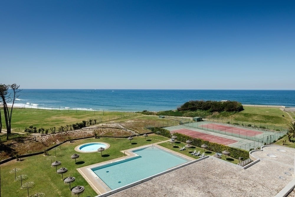 uma piscina com cadeiras ao redor e um bar ao fundo