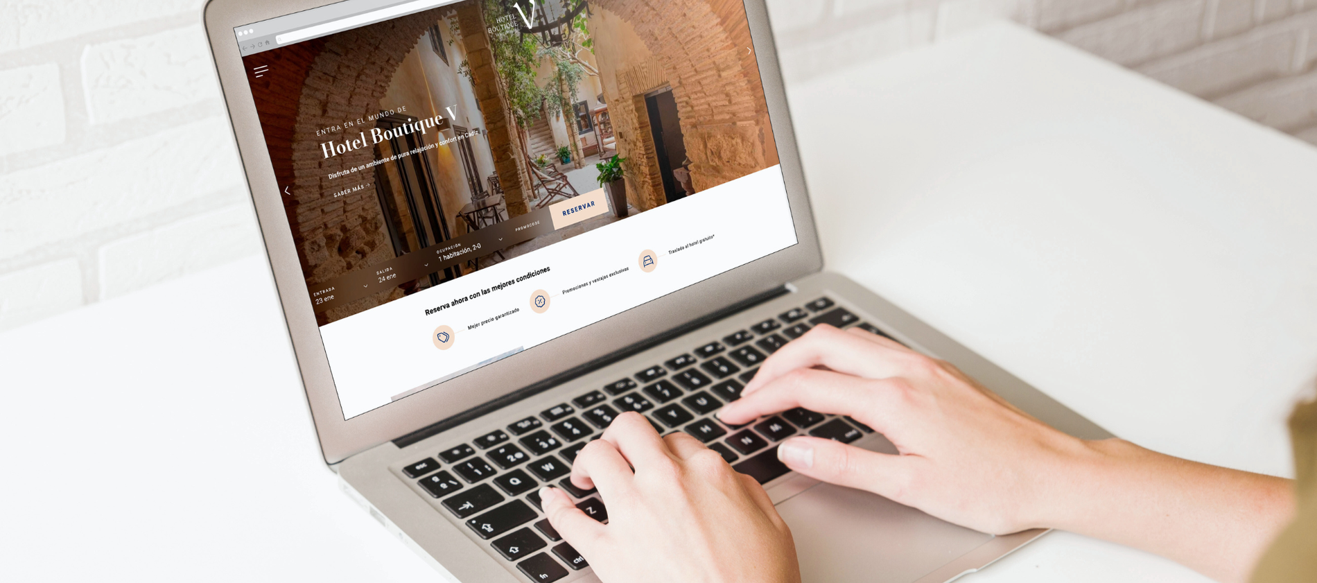 a person is typing on a laptop with a hotel boutique website open