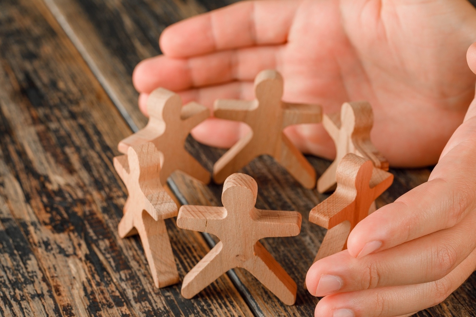 a person is holding a circle of wooden people