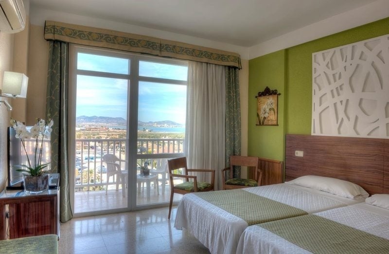 a hotel room with a bed and a green wall