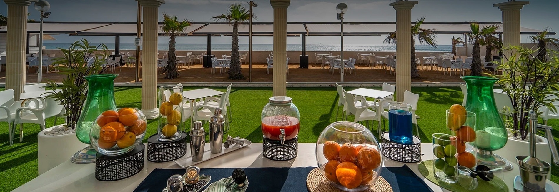 una mesa llena de frutas y bebidas en un restaurante al aire libre