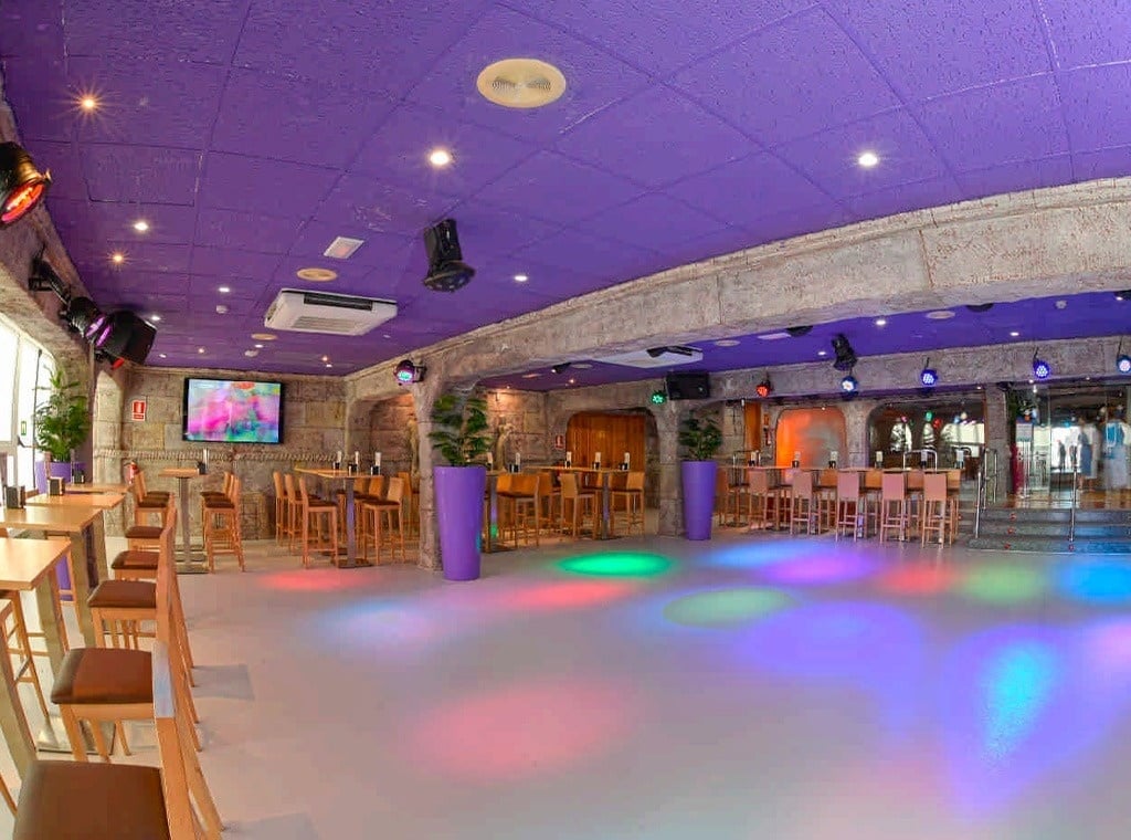 a large room with purple ceilings and tables and chairs