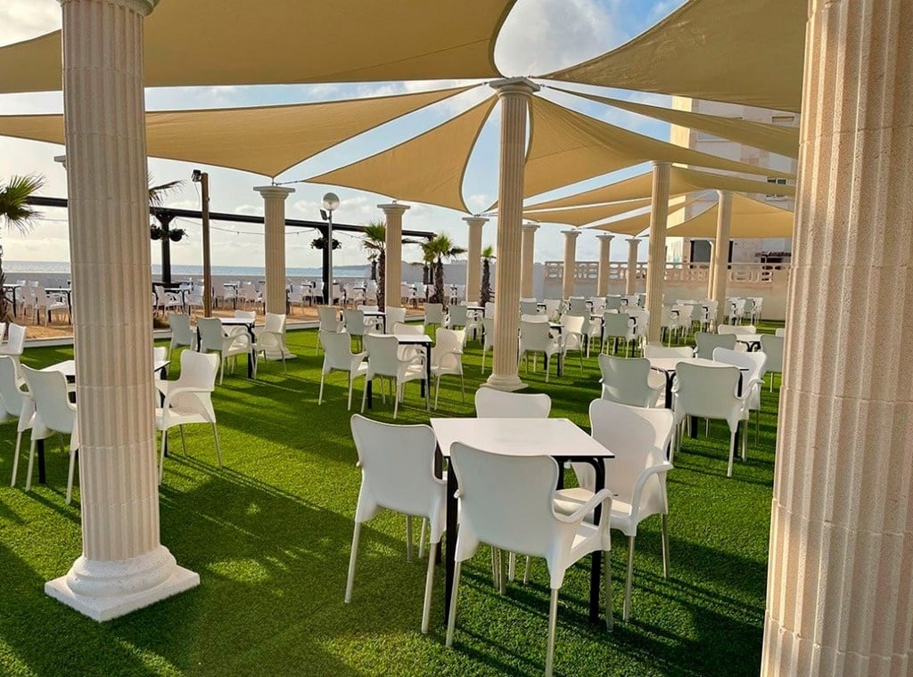 a restaurant with tables and chairs under umbrellas